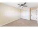 Bedroom with neutral carpet, walls, ceiling fan, and closet space at 3608 W Radcliff Ave, Denver, CO 80236