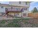 Back exterior shows a two story home with a deck and fenced in yard at 8225 S Cody St, Littleton, CO 80128