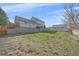 View of the backyard and house, showing deck, retaining wall, and fence at 8225 S Cody St, Littleton, CO 80128