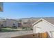 A shot of the backyard with partial view of a detached garage and neighboring houses at 8225 S Cody St, Littleton, CO 80128