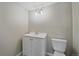 A bathroom featuring a toilet and white vanity with lights above at 8225 S Cody St, Littleton, CO 80128
