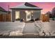 Charming exterior of home with neutral siding, covered in freshly fallen snow at sunset at 402 Harrison Ave, Fort Lupton, CO 80621