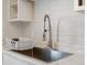 Close-up of a kitchen sink with a modern, brushed-metal faucet and marble-look countertops at 402 Harrison Ave, Fort Lupton, CO 80621