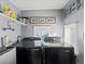 Laundry room featuring black Samsung washer and dryer, overhead storage shelf, and gray walls at 402 Harrison Ave, Fort Lupton, CO 80621