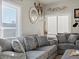 Inviting living room featuring a plush gray sofa, decorative mirrors and bright windows at 402 Harrison Ave, Fort Lupton, CO 80621