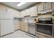Functional kitchen featuring standard appliances, neutral-toned cabinets, and tiled flooring for easy maintenance at 17664 E Loyola Dr # C, Aurora, CO 80013