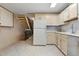 Kitchen features standard appliances, light-colored cabinetry, and tiled flooring, with a staircase leading to another level at 17664 E Loyola Dr # C, Aurora, CO 80013