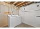 Functional laundry area featuring a modern washer and dryer, exposed ductwork, and concrete foundation at 17664 E Loyola Dr # C, Aurora, CO 80013