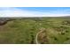 Scenic aerial view of winding trails through a lush green valley and rolling hills with scattered homes at 17223 W 84Th Dr, Arvada, CO 80007