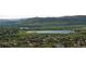 Scenic aerial view of a suburban neighborhood with scenic mountain views, lush greenery, and a peaceful lake at 17223 W 84Th Dr, Arvada, CO 80007