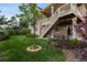 Spacious backyard featuring a grassy area, mature landscaping, and a two-story deck with wooden stairs at 17223 W 84Th Dr, Arvada, CO 80007