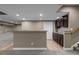 Basement with a wet bar with dark cabinets, granite countertop, and stairs to first floor at 17223 W 84Th Dr, Arvada, CO 80007