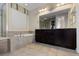 Bathroom showcasing tiled shower, soaking tub, and dual sink vanity at 17223 W 84Th Dr, Arvada, CO 80007