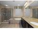 Spacious bathroom with dual sinks, a soaking tub, and a tiled shower at 17223 W 84Th Dr, Arvada, CO 80007