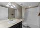 Bright bathroom featuring a large mirror, vanity with sink, and bathtub with white tile surround at 17223 W 84Th Dr, Arvada, CO 80007