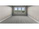 Bright bedroom with three large windows offering scenic views and neutral carpet at 17223 W 84Th Dr, Arvada, CO 80007