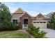 Charming two-story home featuring a well-manicured lawn, brick accents, and an attached two-car garage at 17223 W 84Th Dr, Arvada, CO 80007