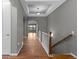 Elegant hallway featuring hardwood floors, tray ceilings, and a staircase with white railing and stained wood at 17223 W 84Th Dr, Arvada, CO 80007