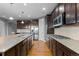 Modern kitchen featuring granite countertops, dark cabinetry, stainless steel appliances and hardwood flooring at 17223 W 84Th Dr, Arvada, CO 80007