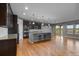 Open-concept kitchen featuring hardwood floors, center island with bar seating, and stainless steel appliances at 17223 W 84Th Dr, Arvada, CO 80007