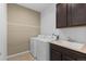 Functional laundry room featuring a washer, dryer, sink and cabinets at 17223 W 84Th Dr, Arvada, CO 80007