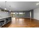 Open-concept living area with hardwood floors, a kitchen island and large windows offering expansive views at 17223 W 84Th Dr, Arvada, CO 80007