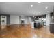 Open floor plan combining living area and kitchen with hardwood floors and modern lighting at 17223 W 84Th Dr, Arvada, CO 80007