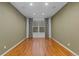 Minimalist room featuring wood floors and a window with decorative curtains, creating a serene space at 17223 W 84Th Dr, Arvada, CO 80007