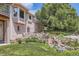 Lush backyard features a water feature surrounded by mature landscaping and a brick home exterior at 7769 W 70Th Dr, Arvada, CO 80004