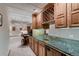 Finished basement wet bar with granite countertops, wood cabinetry and mirrored backsplash at 7769 W 70Th Dr, Arvada, CO 80004