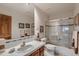 Bright bathroom with a tile countertop, framed mirrors and a glass-enclosed shower at 7769 W 70Th Dr, Arvada, CO 80004