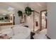 Bright bathroom featuring a jacuzzi bathtub, glass shower, and hanging plants at 7769 W 70Th Dr, Arvada, CO 80004