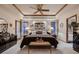 Spacious bedroom with tray ceiling, ceiling fan, and decorative art above the bed at 7769 W 70Th Dr, Arvada, CO 80004