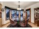 Cozy breakfast nook with large windows, wood floors, and a modern light fixture above the circular table at 7769 W 70Th Dr, Arvada, CO 80004