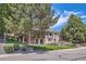 A nicely landscaped exterior with mature trees, a two-story brick facade, and a water feature at 7769 W 70Th Dr, Arvada, CO 80004