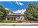 Exterior home view displaying a brick facade, balcony, lush landscaping, and water feature at 7769 W 70Th Dr, Arvada, CO 80004