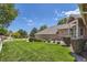 Beautifully landscaped yard with mature trees and manicured bushes adds to the home's appeal at 7769 W 70Th Dr, Arvada, CO 80004