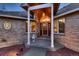 Elegant home entrance with stained glass door, stone accents, decorative columns, and red rock landscaping at 7769 W 70Th Dr, Arvada, CO 80004
