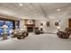 Finished basement living room featuring a brick fireplace, plush seating and neutral carpet at 7769 W 70Th Dr, Arvada, CO 80004