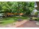 Landscaped backyard with mature trees, a brick patio, and outdoor seating at 12 Long Spur, Littleton, CO 80127