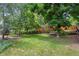 Large grassy backyard with privacy fence, mature trees, and hammock at 12 Long Spur, Littleton, CO 80127