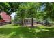 Home exterior with landscaped backyard, brick patio, and mature trees at 12 Long Spur, Littleton, CO 80127