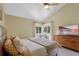 Bright bedroom with vaulted ceiling, ceiling fan, large windows, and dresser with large-screen television at 12 Long Spur, Littleton, CO 80127