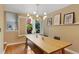 Chic dining room boasts a modern chandelier and a large wooden table, creating an inviting atmosphere for meals at 12 Long Spur, Littleton, CO 80127