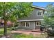 Exterior view of home with fenced backyard, brick patio, and mature trees at 12 Long Spur, Littleton, CO 80127