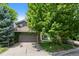 Charming home boasts a two-car garage with basketball hoop and mature landscaping creating a welcoming curb appeal at 12 Long Spur, Littleton, CO 80127