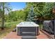 Inviting hot tub set in brick patio, nestled amongst mature trees and landscaping for added privacy at 12 Long Spur, Littleton, CO 80127