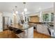 Bright kitchen featuring granite countertops, island with seating, stainless steel appliances, and elegant pendant lighting at 12 Long Spur, Littleton, CO 80127