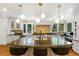 Open kitchen featuring white cabinets, stainless steel appliances, large island with seating, and backyard views at 12 Long Spur, Littleton, CO 80127
