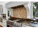 Close up on the kitchen range and exhaust hood with tile backsplash, stainless steel appliances, and granite counters at 12 Long Spur, Littleton, CO 80127